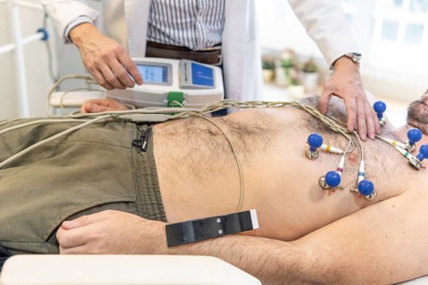 Doctor performing electrocardiogram. Heart exam