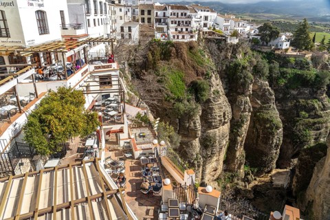 Restaurants high above Tajo de Ronda gorge and the white houses of La Ciudad old town