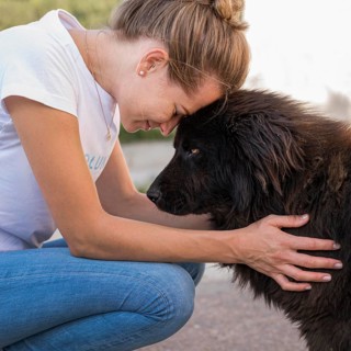 Side view woman with fluffy black dog outdoors
