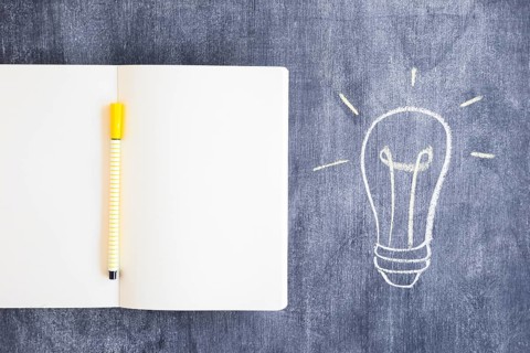 Felt tip pen blank notebook with drawn light bulb chalkboard