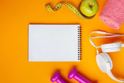 Flat lay notebook apple yellow background