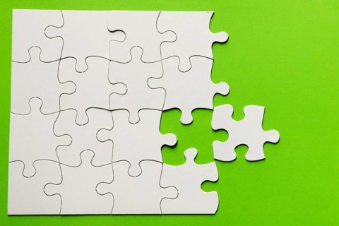 Elevated view cardboard puzzle green background
