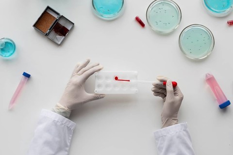 Close up scientist holding pipette