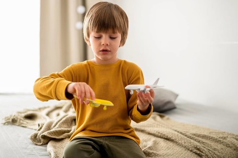 Front view child playing airplane figurines