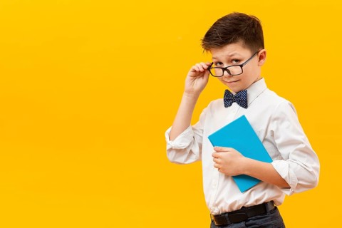 Young boy with glasses holding book