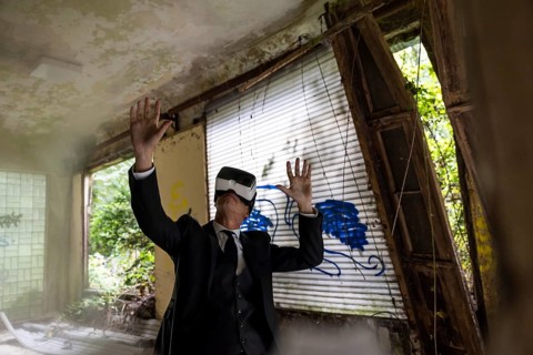 Man dressed in suit wearing VR glasses in a dilapidated office building