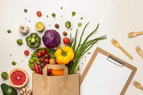 Top view assortment vegetables paper bag with clipboard