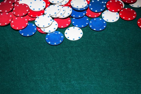 White blue red casino chips green background