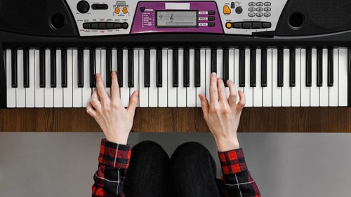 Top view hands playing digital piano