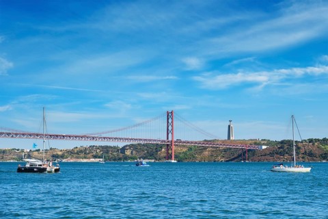View of 25 de Abril Bridge famous tourist landmark over Tagus river