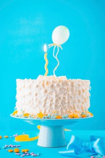 Decorative cake illuminated candle blue backdrop