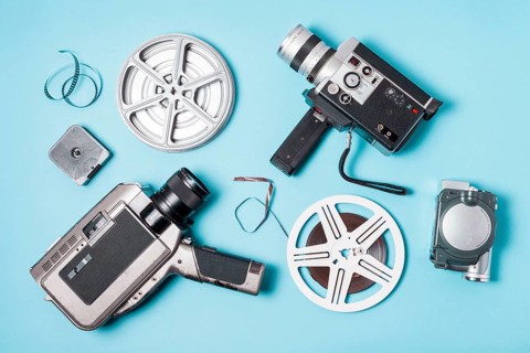 Overhead view film strips film reel various type camcorder blue background