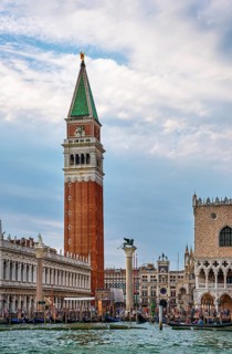 Famous view of St Mark campanile and columns with lion and saint by waterfront of piazzetta of St Mark square on Grand Canal
