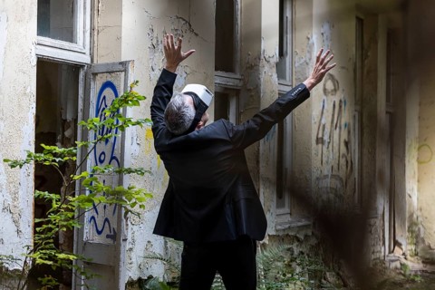 Man dressed in suit wearing VR glasses in a dilapidated office building