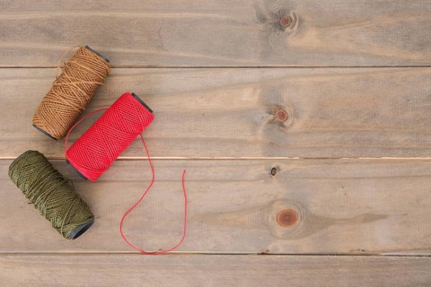 Red brown green yarn spool wooden table
