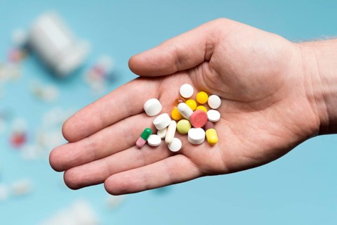 Flat lay hand holding assortment pills