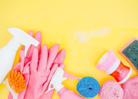 Spray bottle brush sponge pink gloves yellow backdrop