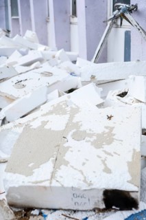 Insulation boards are removed from a facade of a house