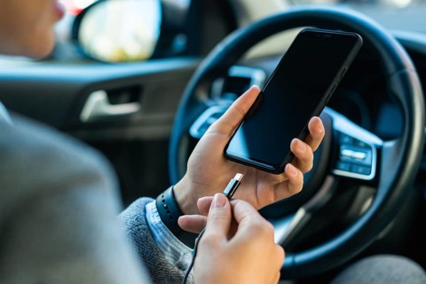 Businesswoman charging her phone car