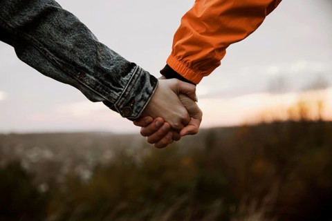 Couple holding hands while road trip together