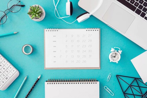 Flat lay desk calendar blue background