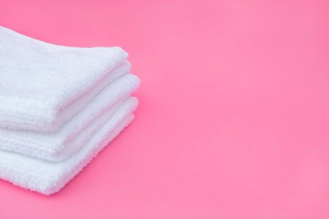 Stack white towels pink background