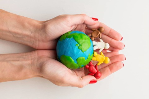 Top view hands holding plasticine globe people