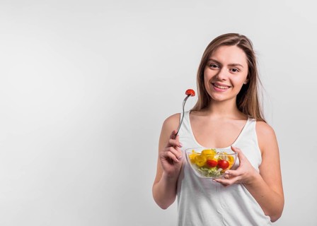 Smiling young woman with bowl salad