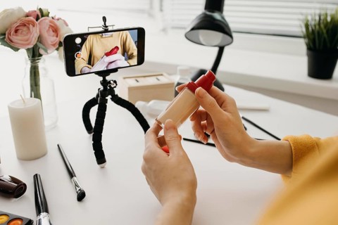 Blogger streaming make up foundation online with smartphone