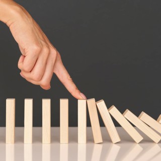 Domino game made with wooden pieces representing finances struggles