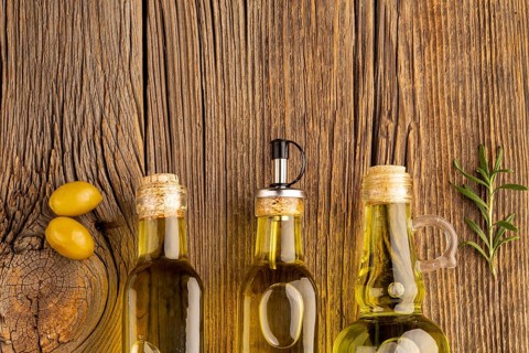 Yellow olives oil bottles wooden background