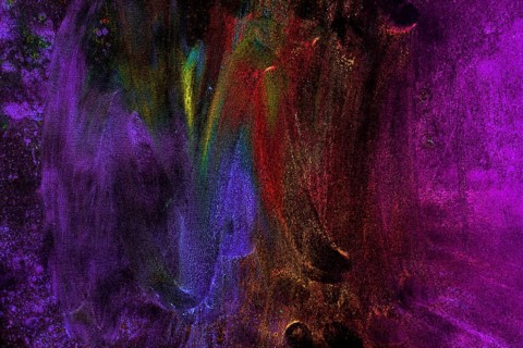 Multicolored holi colors smudged with hand black background