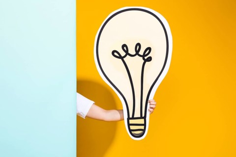 Portrait schoolgirl with big light bulb