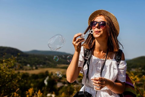Woman white dress making soap bubbles