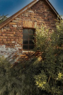 Old brick house with mullioned window in the sunlight