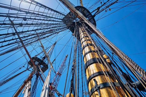 Masts of old wooden Age of sail sailing ship with ropes cordage and shroud and crow's nest