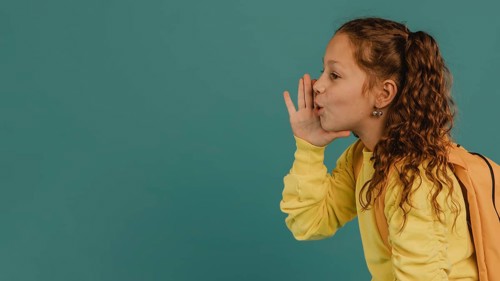 School girl with yellow shirt telling secret