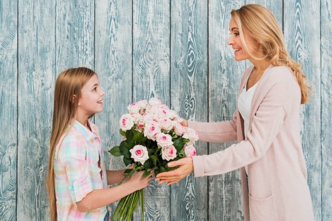 Daughter presenting mother bouquet roses