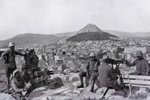 Greek soldiers stationed on the Acropolis with a canon and a machine gun in front of the Lycabettus mount
