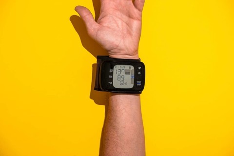 Blood pressure monitor on a man's trading joint against a yellow background