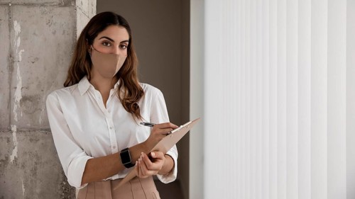 Front view businesswoman with mask clipboard