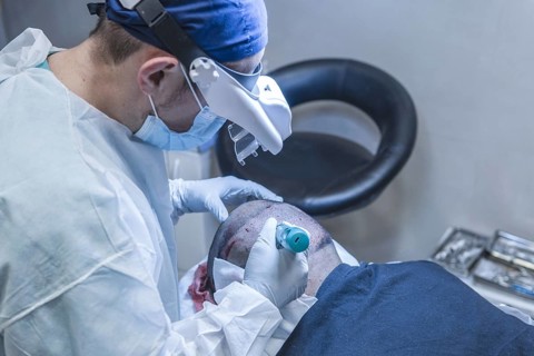 Hair transplant. Surgeons in the operating room carry out hair transplant surgery