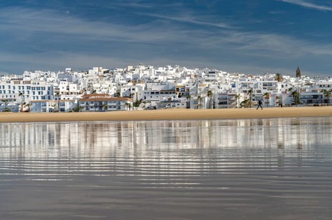 The town view of Conil reflected on the beach Playa De Los Bateles