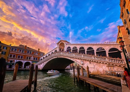 Sunset view of famous bridge of Rialto or ponte di Rialto over Grand Canal