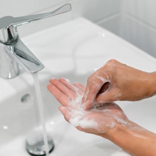 Person washing hands with soap
