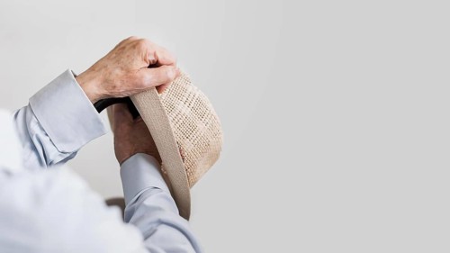 Old man holding hat cane