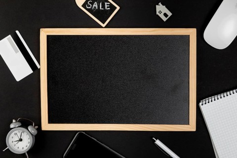 Black whiteboard with desk stuff around