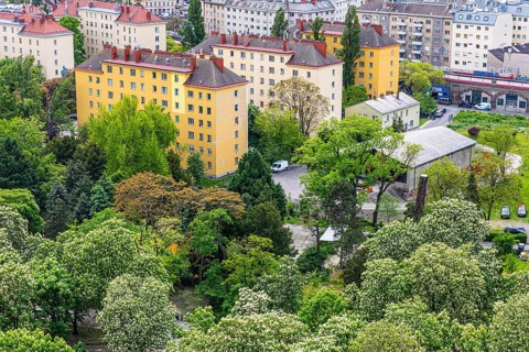 Older apartment blocks at the Prater amusement park surrounded by flowering deciduous trees