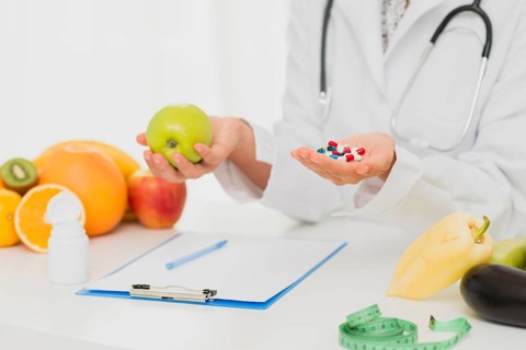 Doctor with pills fresh fruits