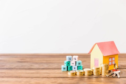Math blocks house key stacked coins wooden surface